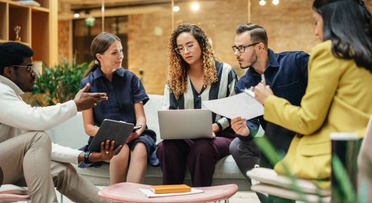 A professional team in a business meeting around a conference table.
