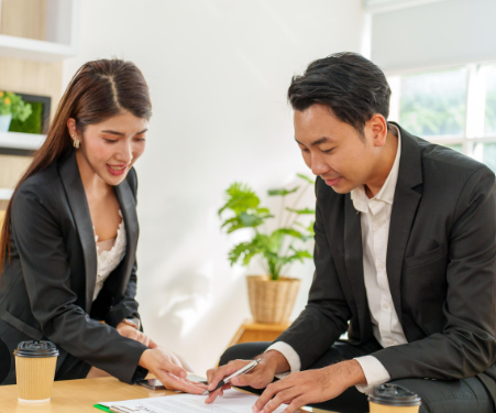Two Indian professionals discussing a project on a laptop.